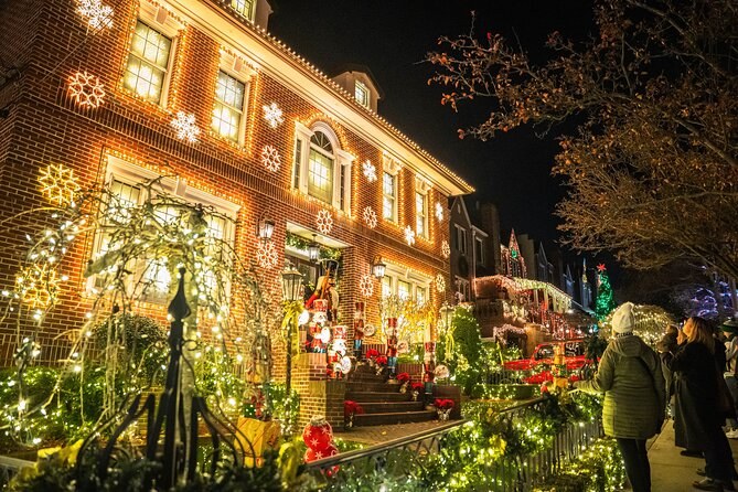 A large Dyker Heights house wrapped in warm gold lights, with the bare trees in front of it lit to match