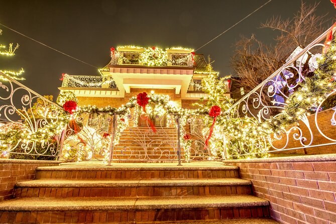 A front staircase and railings picked out in warm gold lights and red bows in Dyker Heights