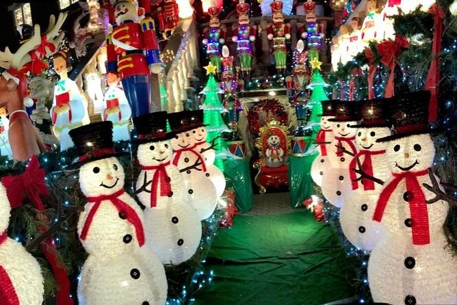 A row of glowing snowmen in top hats and scarves set along a Dyker Heights front garden
