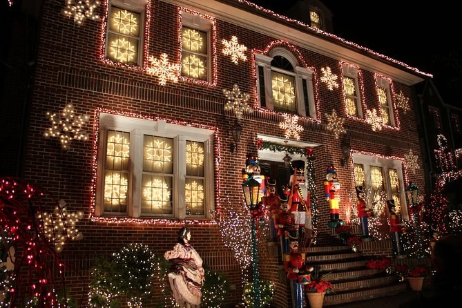 White snowflake lights across the brick front of a Dyker Heights house at night